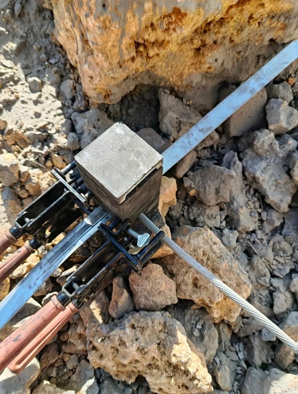 Moule de soudure aluminothermique maintenu par sa pince sur une connexion câble